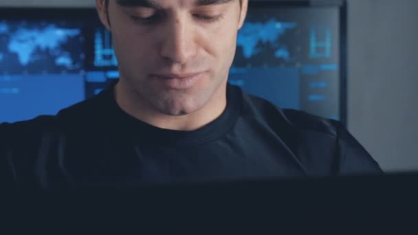 Programmatore sviluppatore che lavora su computer in un data center pieno di schermi di monitor. Steadicam shot — Video Stock