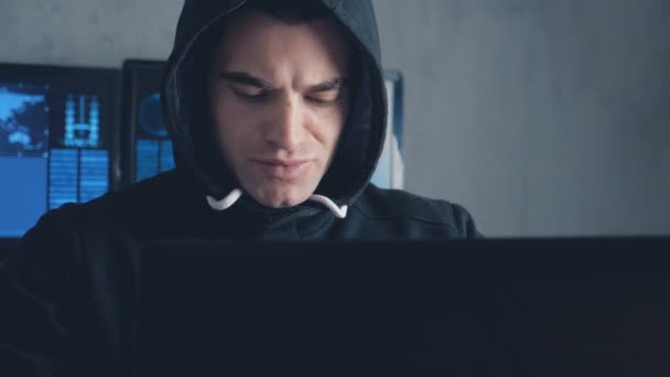 Gesuchter Hacker in Kapuze arbeitet an Computer in Rechenzentrum. — Stockvideo