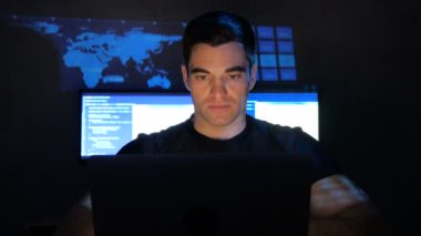 monitör ekranlarla dolu bir veri merkezi kamerada geliştirici programcı portresi yakından bakar. Monitör ekran yüzü yansıtılır