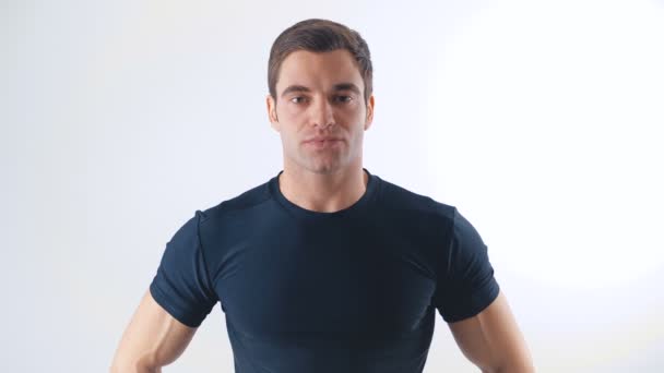 Portrait of athletic guy in a black t-shirt on white background — Stock Video