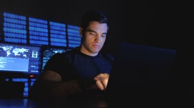 Bilgisayar monitörü ekranlarla dolu bir veri merkezinde çalışan geliştirici hacker programcı portresi