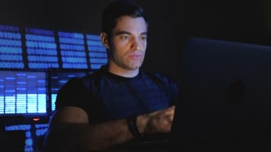 Yakışıklı erkek programcı bir bilgisayarda çalışma gece ofiste monitör ekranlar ile doldurdu