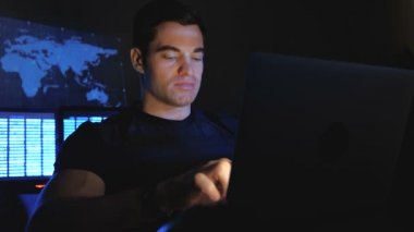 Yakışıklı erkek hacker programcı bir veri merkezi monitör ekranlar ile doldurdu geceleri bir bilgisayarda çalışıyor