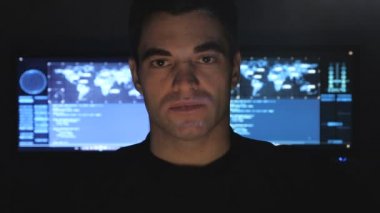 portre yakışıklı hacker programcı monitör ekranlarla dolu bir veri merkezindeki kapatın