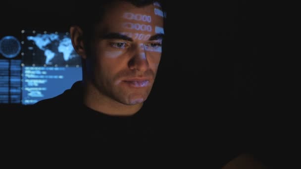 블루 코드 문자는 어두운 사무실 룸에서 그의 얼굴에 반영 하는 동안 컴퓨터에서 작업 하는 남자 프로그래머 해커. — 비디오