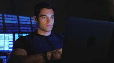 Bilgisayar monitörü ekranlarla dolu bir veri merkezinde çalışan geliştirici programcı portresi.