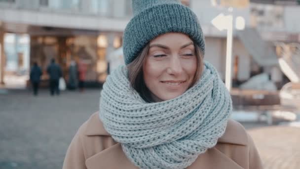 Porträt einer hinreißenden jungen Frau mit Strickmütze im Freien. attraktive junge Frau lächelt auf der Straße — Stockvideo