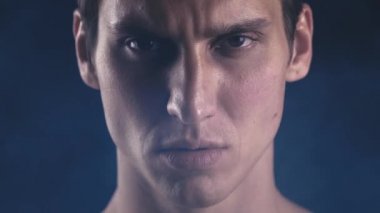 Yakın çekim portre. Kendine güvenen güçlü adam kameraya bakıyor. Atlet ciddi göz şampiyonu odaklı