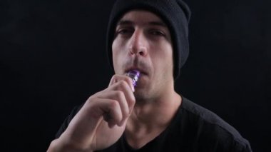 duman e-sigara vape yavaş çekimde siyah arka plan üzerine ile büyük bulutlar exhaling genç adam vaper