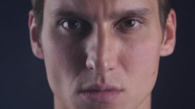 Genç adam portresi yakından gözlerini açar ve kamera siyah bir arka plan içine bakıyor
