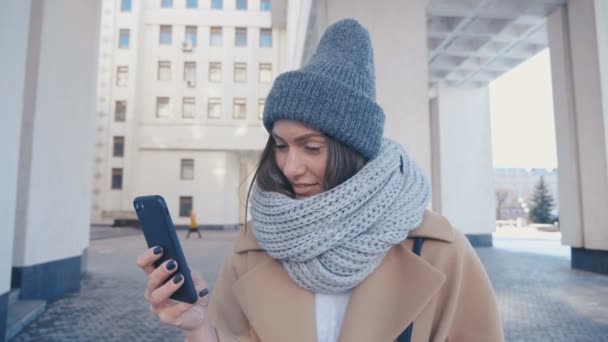 세련 된 복장 검사 스마트폰 도시 배경에서 야외에서 젊은 매력적인 여자의 클로즈업 초상화 — 비디오