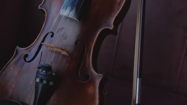 Violín con arco tumbado en la habitación cerca de la ventana. Tiro de leva constante . — Vídeo de stock