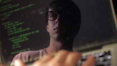 Çift Pozlama: bir dizüstü bilgisayarda çalışan gözlük adam hacker. Programcı ekranda yeşil kod yansıması yazar