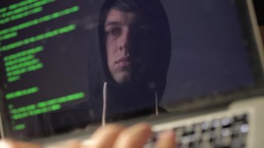 Çift Pozlama: bir dizüstü bilgisayarda çalışan gözlük adam hacker. Programcı ekranda yeşil kod yansıması yazar