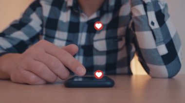 Kullanan genç adam kadar yakın ve smartphone ile oynarken seviyor ve simge akıllı telefonun kayan seviyor