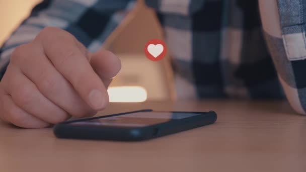 Молодой человек, пользующийся смартфоном с лайками и любимыми иконками, выплывает из смартфона — стоковое видео