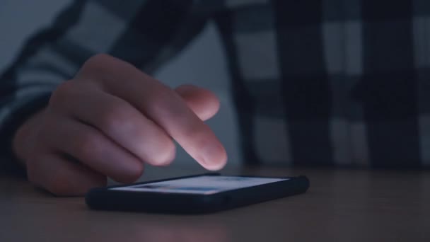 Man hand finger scroll on smartphone in dark. — Stock Video