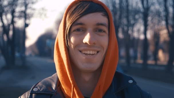 Kentsel arka planda şehirde gülümseyen kırmızı hoodie mutlu beyaz adam portresi — Stok video