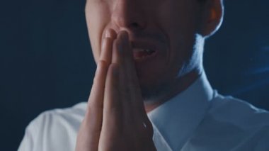 Umutsuzluk içinde dua eden depresif bir işadamının yakın çekim. İş hayatında ki sorunlar kavramı.