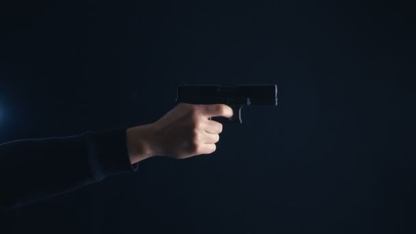 Close-up Gun in hand on a black background. — Stock Video