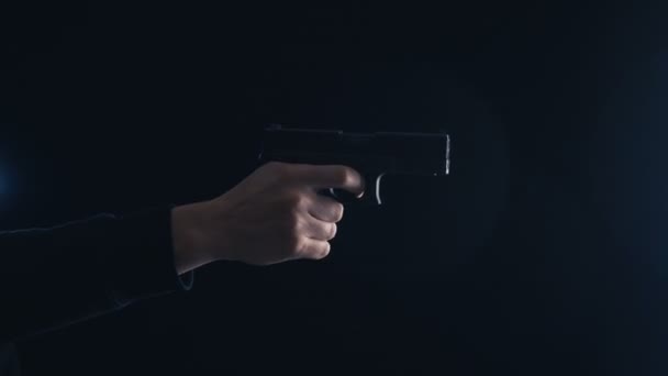 Pistola de cerca en la mano sobre un fondo negro . — Vídeos de Stock