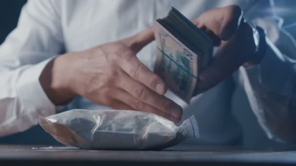コカインバッグとピストルで麻薬ディーラーのクローズアップはお金をカウントします。犯罪者の世界. — ストック動画
