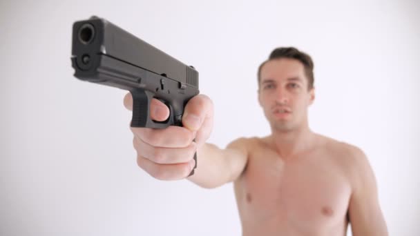 벌거 벗은 남자 는 흰색 배경에 자신의 총을 목표로 — 비디오