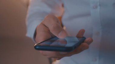 Gece büyük bir siyah smartphone üzerinde haber hattı kaydırma erkek el