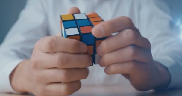 Kiev, Ucrania, 07 de mayo de 2019: Un hombre de negocios con camisa blanca intenta resolver el cubo de Rubiks — Vídeos de Stock