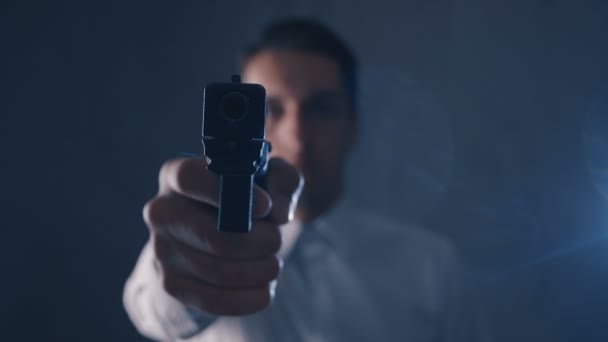 Gefährlicher Geschäftsmann, der eine Waffe in eine Kamera richtet. Fokus auf Waffe. — Stockvideo
