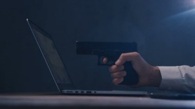 Erkek el bilgisayar ekranında silah hedefliyor. Siber soygun kavramı.