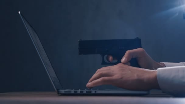 Arm with gun aims at a screen of laptop. Cyber robbery. — Stock Video
