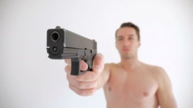 Çıplak adam beyaz arka plan üzerine silahını hedefliyor
