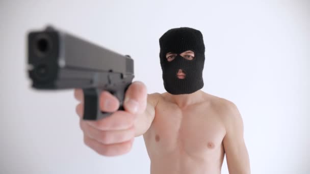 Terrorist med en naken Torso i Balaclava syftar hans pistol på vit bakgrund — Stockvideo