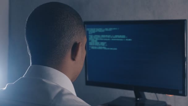 Vista posterior del código de programación profesional del programador en el monitor de la computadora en la oficina nocturna — Vídeos de Stock