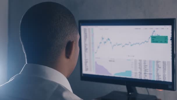 Afro-americký podnikatel v bílé košili analyzuje prodejní trh. Zpětné zobrazení Stockbroker pracuje s finančním trhem v úřadu. — Stock video