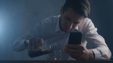 Depresif işadamı karanlık bir odada tek başına içen bir bardak viski dökün. Alkolizm kavramı.