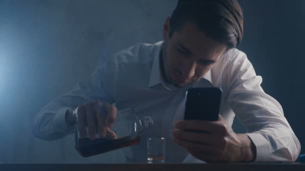 Depressieve zakenman pour whiskey in een shot glas drinken alleen in een donkere kamer. Concept van alcoholisme. — Stockvideo