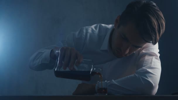 Депресивний бізнесмен вливає віскі в склянку, що п'є поодинці у темній кімнаті. Концепція алкоголізму . — стокове відео