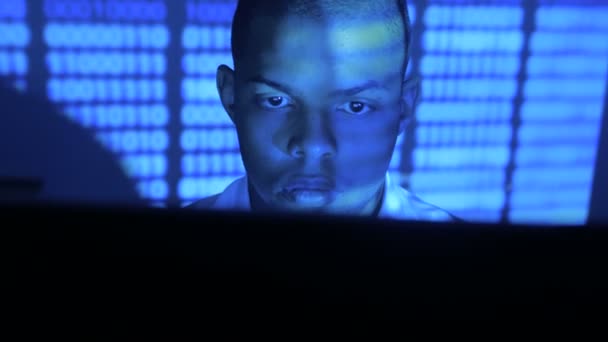 Porträtt av afroamerikansk man programmerare kodning nätverk säkerhetsprogram. Hacker skriva kod på datorskärmen i mörkt kontor på natten — Stockvideo