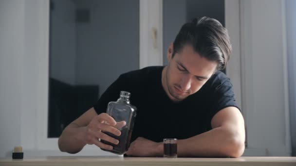 우울한 남자는 부엌에서 혼자 유리에서 위스키를 마시는. 알코올 중독의 개념. — 비디오