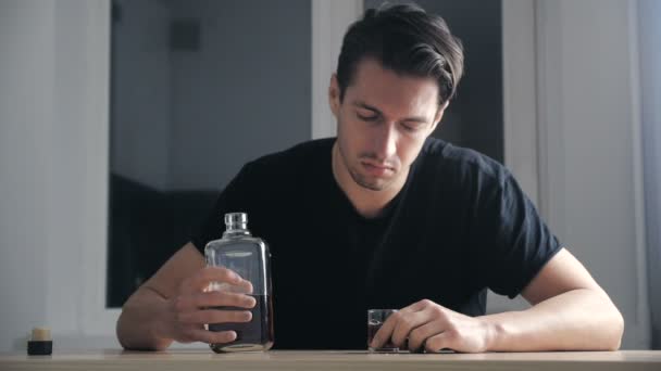 Przygnębiony człowiek picia whisky ze szkła sam w kuchni. Koncepcja alkoholizmu. — Wideo stockowe