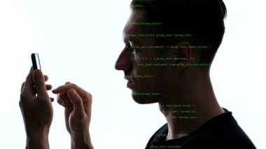 Üzerinde yeşil kod olan akıllı telefonu kullanan bilgisayar korsanının çifte pozlaması. Akıllı telefon kullanarak adam programcı çift sergi