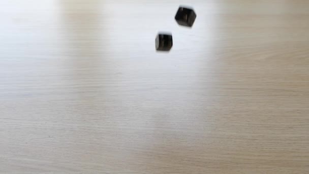 Rolando um par de dados de jogo preto em uma mesa em câmera lenta — Vídeo de Stock