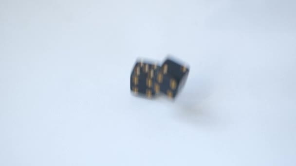 Rolling a five and a four with a pair of black gambling dice on a white table in slow motion — Stock Video