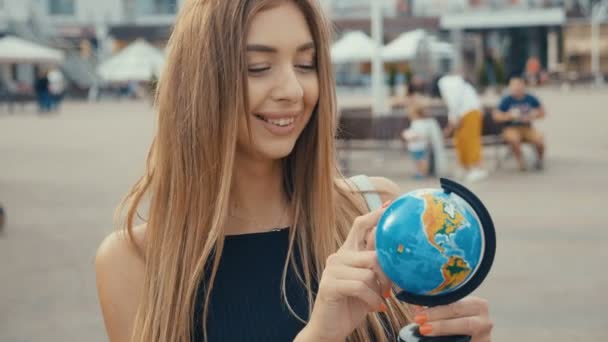 Porträtt av ung kvinna vrida Globen, Outdoor shot — Stockvideo