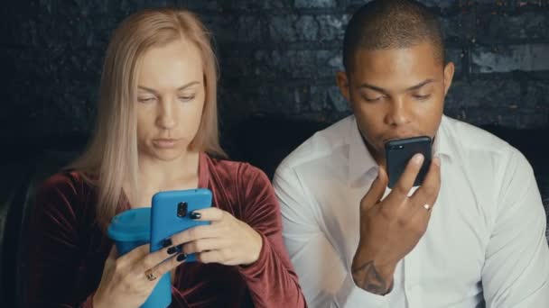 Multi-étnico multirracial pareja ocupada usando smarkphone en la cafetería o cafetería . — Vídeo de stock