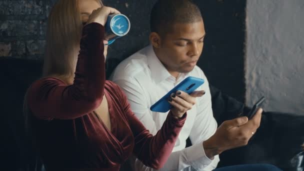 Kafe veya ofis arka planda akıllı telefon kullanarak Karışık ırk çift. Erkek ve kadın iletişim ve akıllı telefonlar kullanın — Stok video