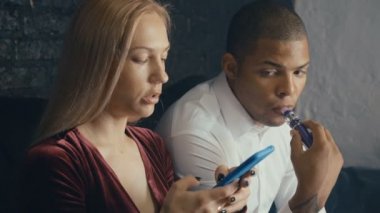 Kahvehanede konuşan çok ırklı çift, vape içen adam ve restoraunt'ta kahve içen kadın, kafede buluşmada pazarlık eden farklı insanlar