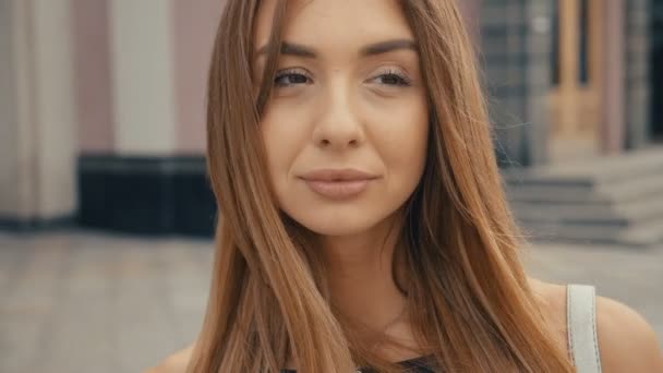 Cute young woman on the street look at camera, steadicam shot. Beautiful portrait fashion summer face female close up — Stock Video